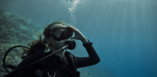 Plongeur en immersion portant un masque de plongée à réalité augmentée dans une eau bleue